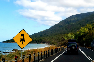 A car driving along Australian coast with podcast street sign