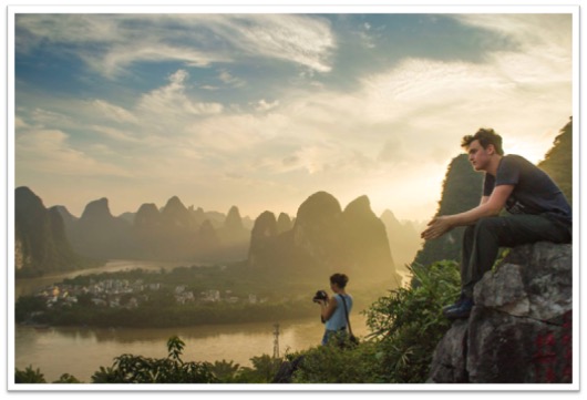 Photo of a student sitting in the Mountains